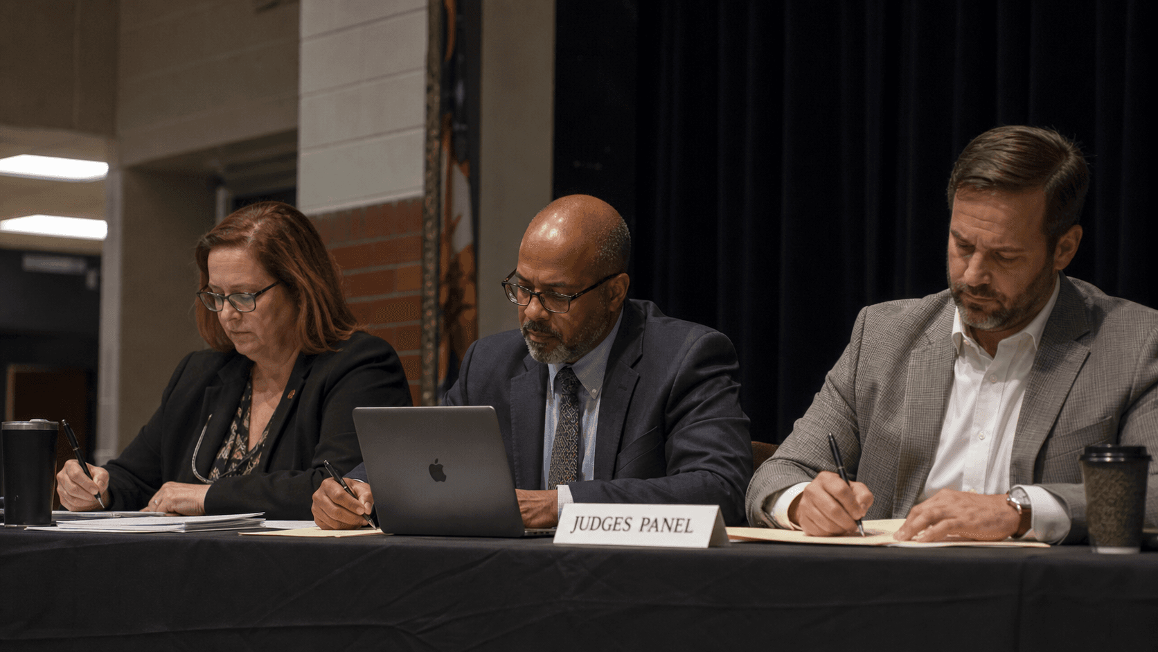 A panel of judges evaluating student debaters at a school tournament.